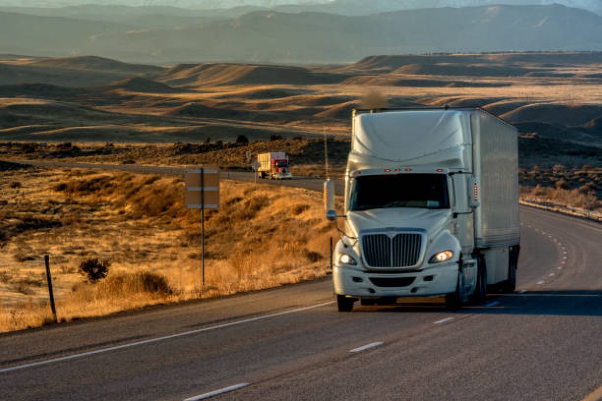 Long Haul Semi-Truck Rolling Down a Four-Lane Highway at Dusk